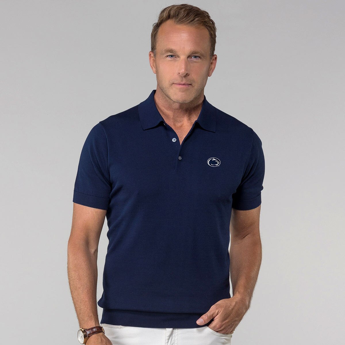 model wearing navy cotton/silk polo shirt with embroidered Penn State Athletic Logo on left chest